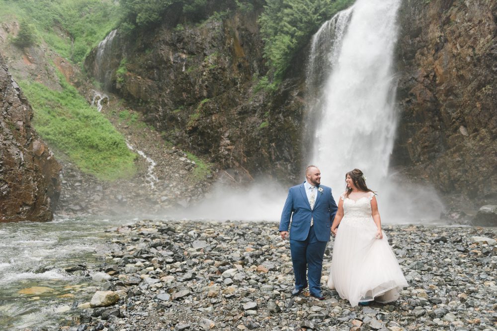 bride-and-groom-walk-away-from-waterfall