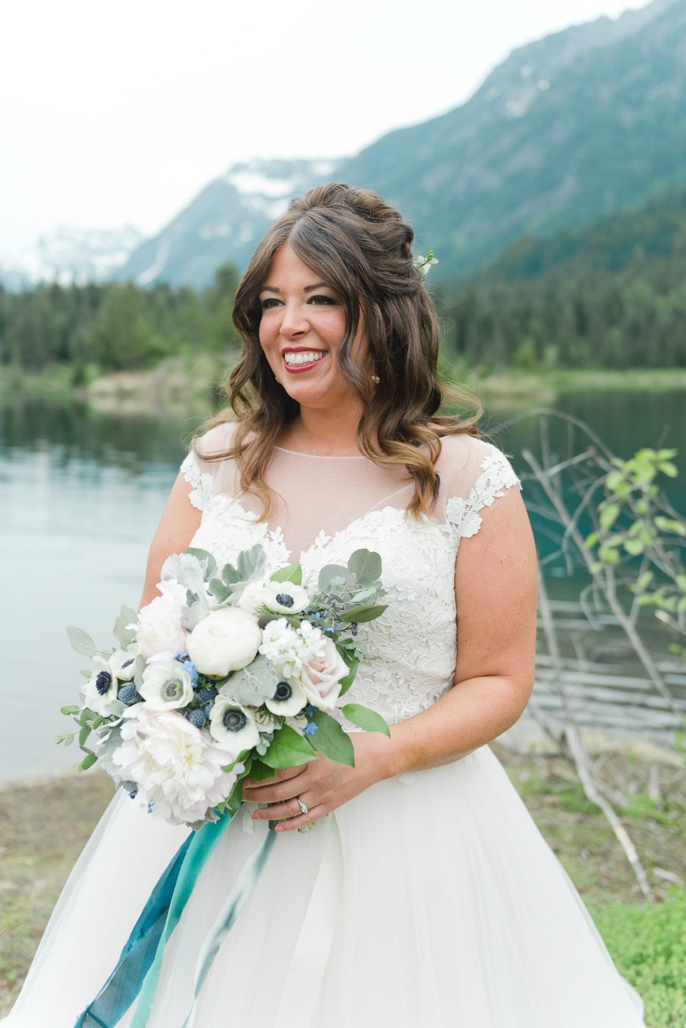 bride-with-white-bouquet-at-mountain-lake
