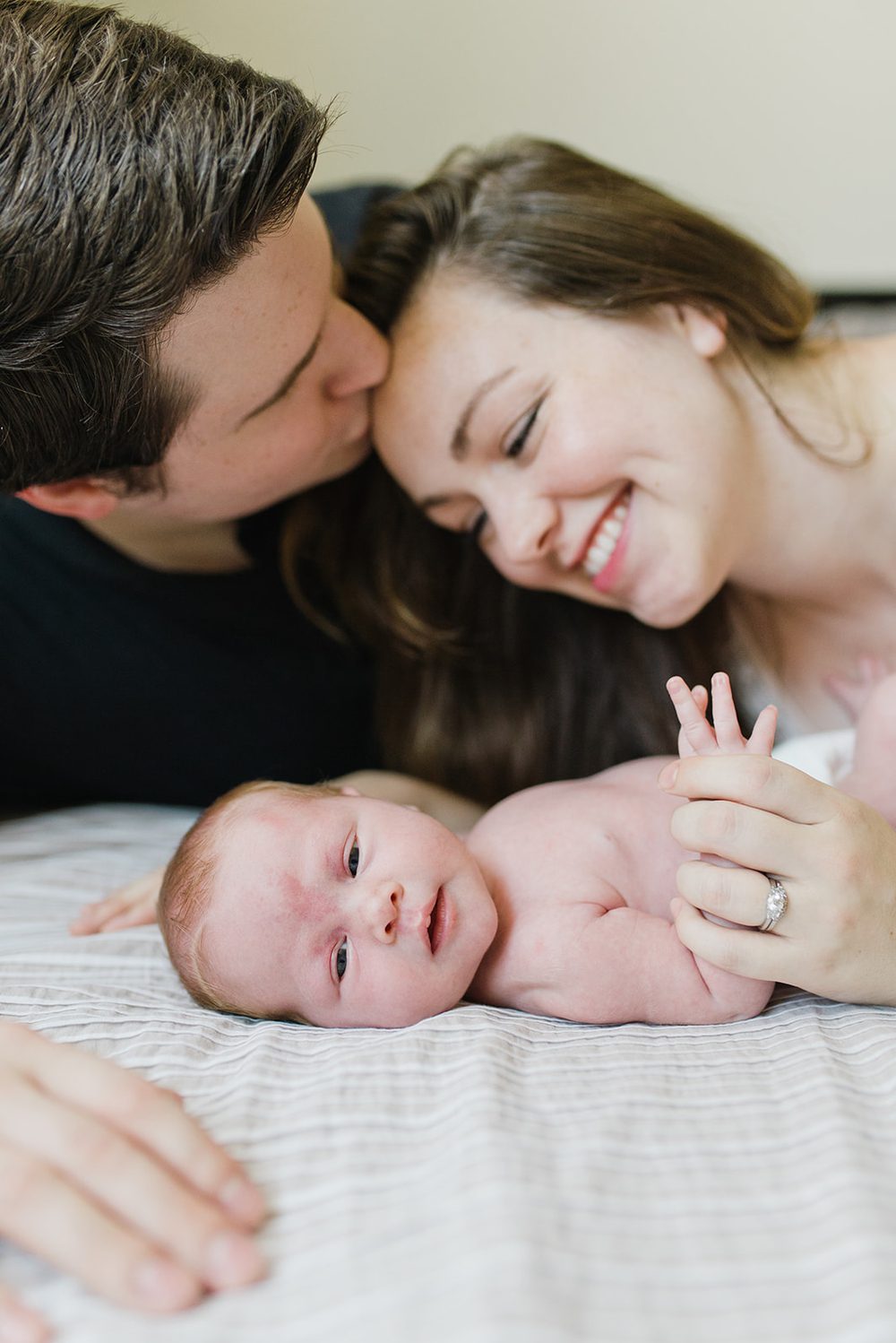 couple-kissing-with-newborn