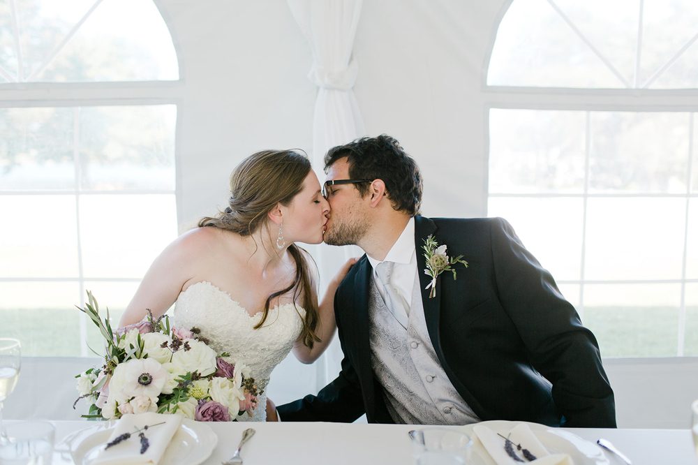 bride-and-groom-kiss-at-head-table